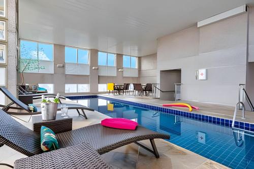 an indoor pool with chairs and a swimming pool at Get a Flat 1403 localização Nobre in São Paulo