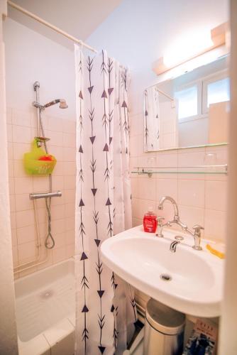 une salle de bain avec un lavabo et un rideau de douche dans l'établissement Les Tilleuls 24 - balcon vue montagne, à Orcières