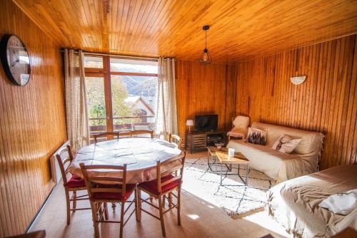 ein Wohnzimmer mit einem Tisch und einem Sofa in der Unterkunft Les Tilleuls 24 - balcon vue montagne in Orcières