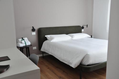 a bedroom with a large bed with white sheets at Kalé in Pordenone
