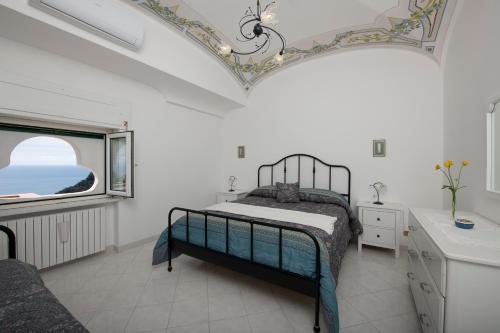 a white bedroom with a bed and a window at Donna Luisa Suite 9 Amalfi sea view - free parking in Scala