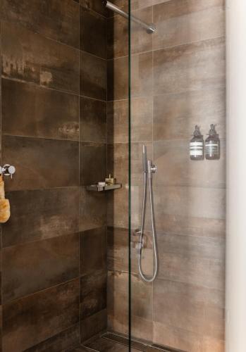 a bathroom with a shower with a glass door at The Hamlet - Luxury Serviced Apartments in Geneva