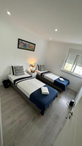 a bedroom with two beds and a window at airport room in Lisbon
