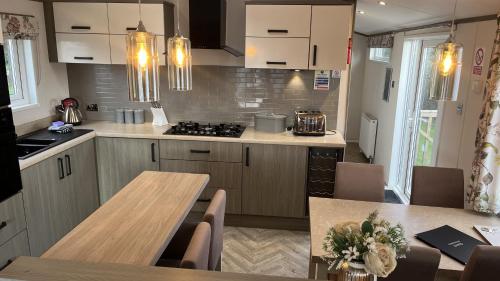 a kitchen with a table and a stove top oven at 2-Bed Lodge Near Garstang and Poulton-Le-Fylde in Preston