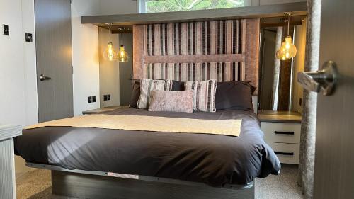 una camera con un grande letto con testiera in legno di 2-Bed Lodge Near Garstang and Poulton-Le-Fylde a Preston