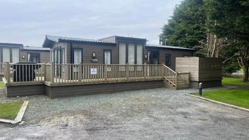 a home with a deck and a house at Cosy 3-Bed hot tub Lodge in Pr3 in Preston