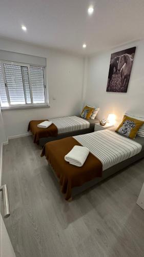 two beds in a room with two windows at airport room in Lisbon