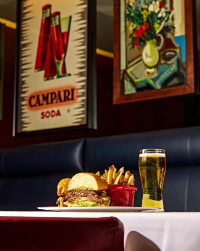 a sandwich and fries on a table with a glass of beer at Thompson Dallas, by Hyatt in Dallas