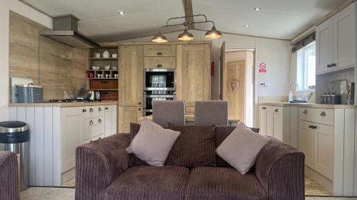 un soggiorno con divano in cucina di Immaculate 3-Bed Lodge in Out Rawcliffe a Great Eccleston