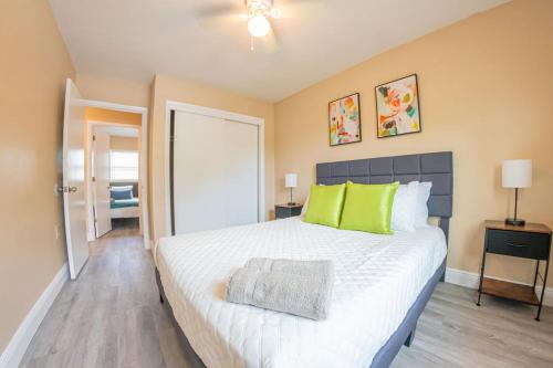 坦帕的住宿－Delray Family House With Hot Tub，卧室配有带绿色枕头的大型白色床