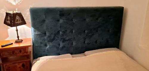 a bed with a black headboard next to a desk at Seaside apartment in Krk