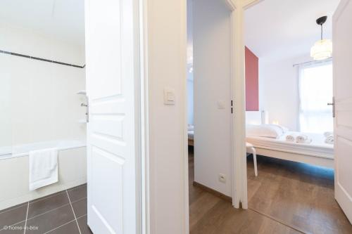 a bathroom with white cabinets and a bedroom with a bed at Disney à 10 min: Maison paisible 8P, Wifi, Parking in Chessy