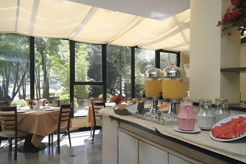 una cucina con tavolo, sedie e finestre di Get a Flat 909 - Conforto Ibirapuera a San Paolo