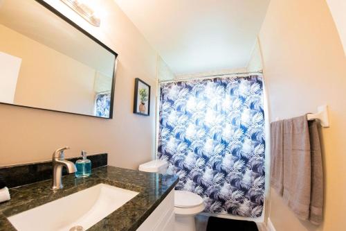 een badkamer met een blauw en wit douchegordijn bij Delray Family House With Hot Tub in Tampa