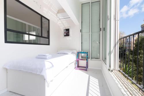 a balcony with white furniture and a large window at Cozy 2BR Heart in Tel Aviv in Tel Aviv