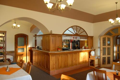 een restaurant met een bar in het midden van een kamer bij Hotel Atawa in Raby