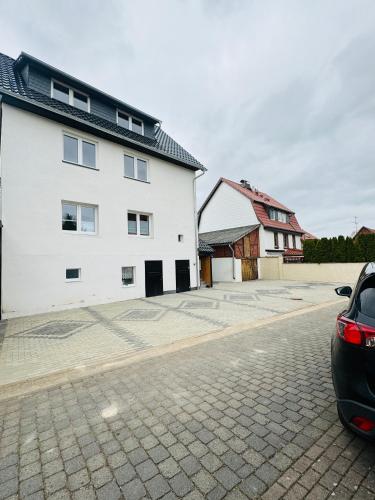 a car parked next to a white building at Sollstedt Ferienwohnung in Sollstedt