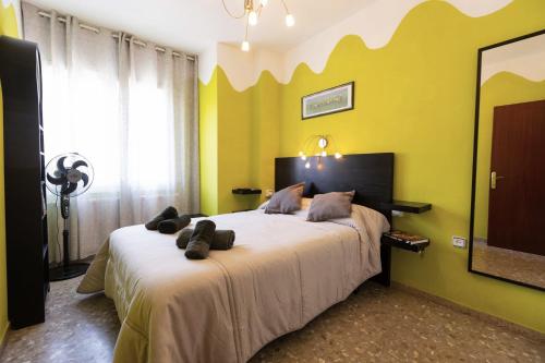 een slaapkamer met een groot bed met een gele muur bij David's House in Barcelona
