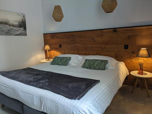1 dormitorio con 1 cama blanca grande y 2 lámparas en L'Ile sous le Vent en Sainte-Marie-de-Ré