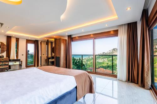 a bedroom with a large bed and large windows at Alanya Luxury Villas in Alanya