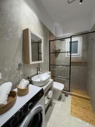 a bathroom with a washing machine and a sink at Terpsichore's House in Sami