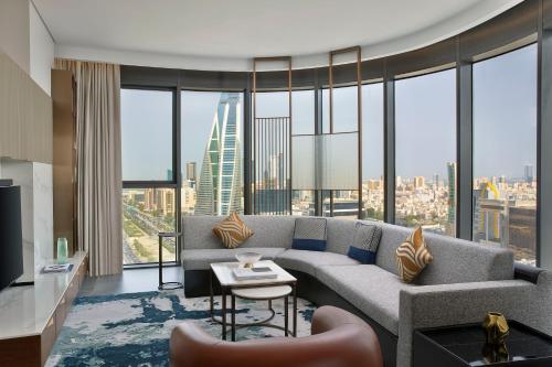 a living room with a couch and a large window at Conrad Bahrain Financial Harbour in Manama