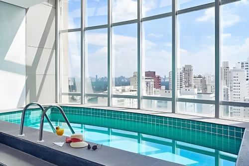 a swimming pool in a large building with windows at Get a Flat 701 - Ibirapuera -Jardins in Sao Paulo