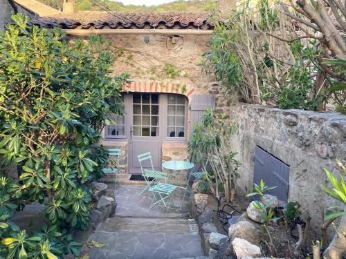 uma casa de pedra com uma mesa e um pátio em Belle Maison de village em Ramatuelle