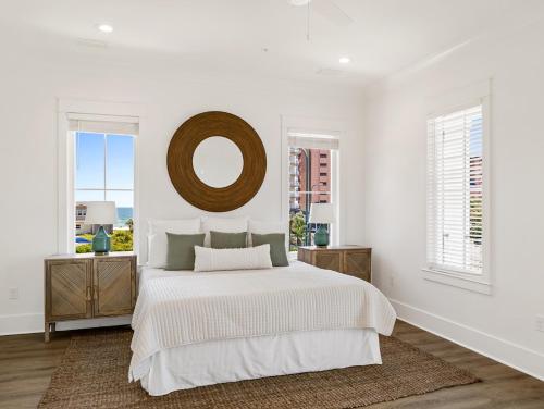 Un dormitorio blanco con una cama y un espejo. en Ta-Kee-La Sunset at The Osprey, en Orange Beach