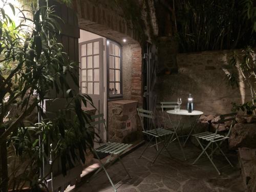 uma mesa e cadeiras num quarto com uma janela em Belle Maison de village em Ramatuelle