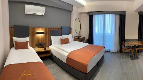 a hotel room with two beds and a desk at ROİ HOTEL İZMiR in İzmir