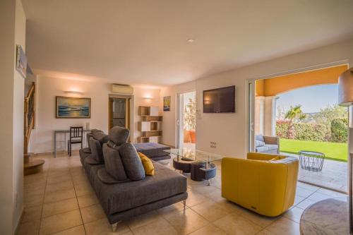 un salon avec un canapé et une chaise jaune dans l'établissement Family home in Sainte-Maxime, à Sainte-Maxime