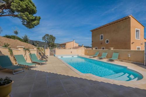 une piscine avec des chaises et une maison dans l'établissement Family home in Sainte-Maxime, à Sainte-Maxime