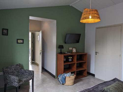 a living room with a television and a table and a chair at L'Ile sous le Vent in Sainte-Marie-de-Ré
