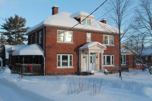dom z czerwonej cegły z śniegiem na ziemi w obiekcie Maison Sherman's house w mieście Scotstown