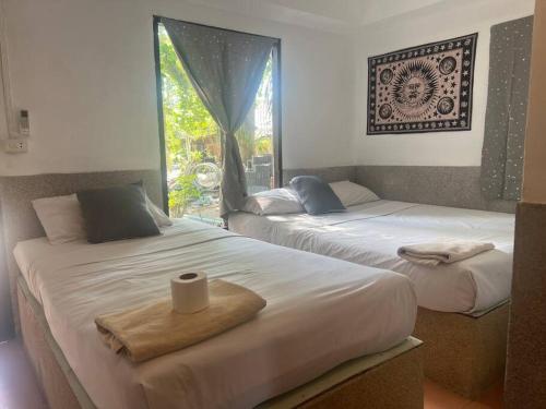two beds sitting next to each other in a room at Sunset Serenity Cove in Ko Phangan