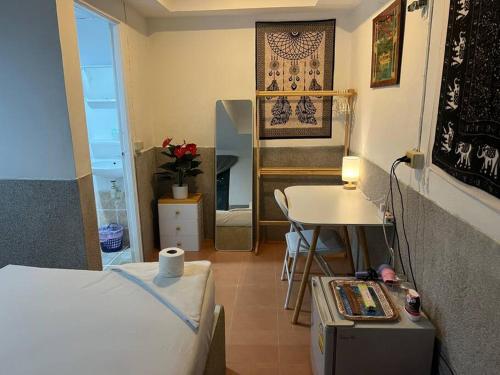 a small room with a bed and a table and a desk at Sunset Serenity Cove in Ko Phangan