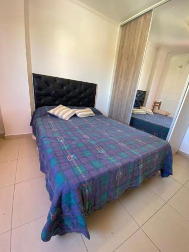 a bedroom with a bed with a blue comforter at DEPARTAMENTO EN PARANÁ ZONA CENTRO in Paraná