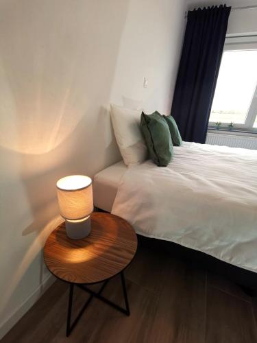 a bedroom with a bed and a table with a lamp at Ten Velde - vakantiewoning 12 personen - sauna - bubbelbad in Hoeselt