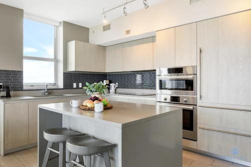 eine Küche mit einer großen Insel mit Barhockern in der Unterkunft Luxury 3 Br- Front Intercostal View - Amazing Pools in Hollywood