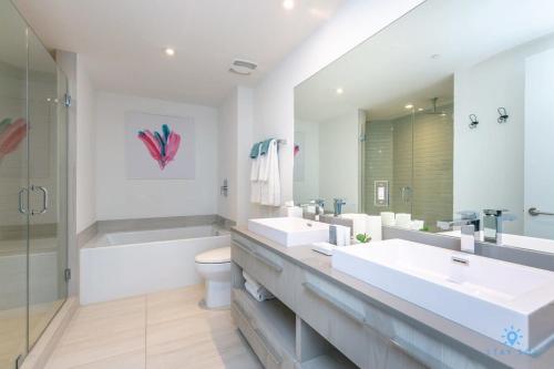 La salle de bains est pourvue de 2 lavabos, d'une baignoire et de toilettes. dans l'établissement Corner Balcony - Enjoy 360 Views- Near Beach- Pool, à Hollywood