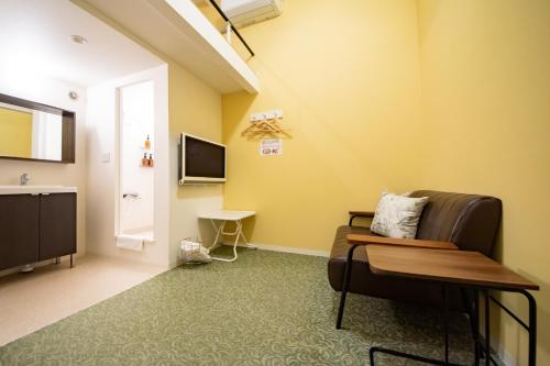 a living room with a couch and a television at Apartment Sanjo in Nara