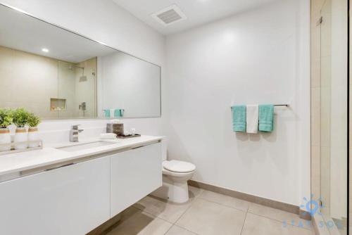 a bathroom with a sink and a toilet and a mirror at Rooftop Pool & Hot Tub - Gym - Hollywood Beach in Hollywood