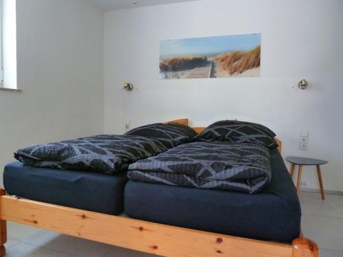 a bed with pillows on it in a room at Ferienhaus Schönach in Herdwangen-Schönach