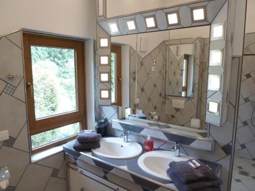 a bathroom with two sinks and a large mirror at Ferienhaus Schönach in Herdwangen-Schönach