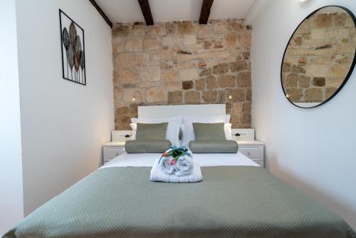 um quarto com uma cama e uma parede de pedra em Manero em Trogir