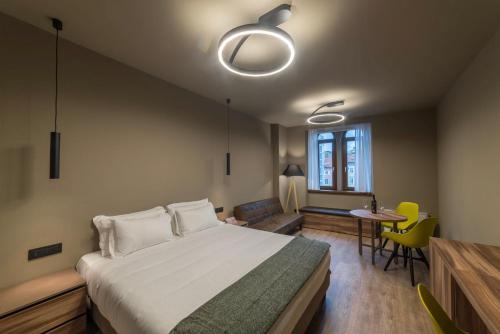 - une chambre avec un grand lit, une table et des chaises dans l'établissement 9 stanze - Boutique Rooms, à Trieste