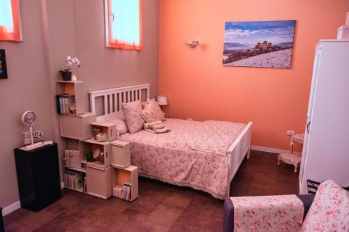 ein kleines Schlafzimmer mit einem Bett und einem Stuhl in der Unterkunft Casa Chiara suite Sole in Parma