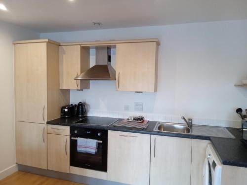 a kitchen with a sink and a stove top oven at Hamilton Court Apartments from Your Stay Bristol in Bristol