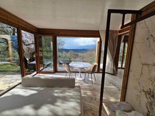 a living room with a table and chairs and a view at EcoResort Il Cantico della Natura in Magione